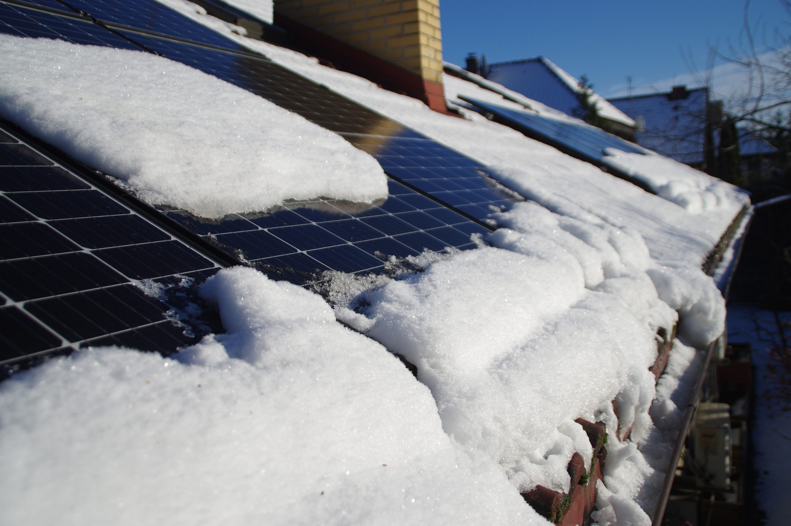 Solar PV panels covered by snow on the home roof during winter